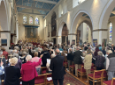 2025_04_13 Palm Sunday IMG_6172 A packed congregation in St Thomas' waving their palm crosses